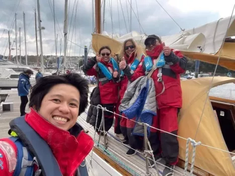 A group of people on a sailing trip, with a woman smiling at the camera